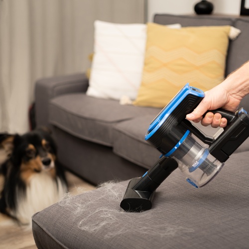 Ruční režim vysavače TESLA Purestar E70 Aqua Pro sbírající zvířecí chlupy na gauči, ideální pro domácnosti s domácími mazlíčky.