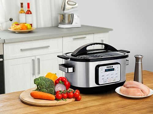 TESLA MultiCook M80 Deluxe na kuchyňském stole se zeleninou a masem