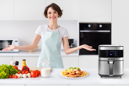 Kuchyně s kuchařkou a připraveným jídlem z fritézy